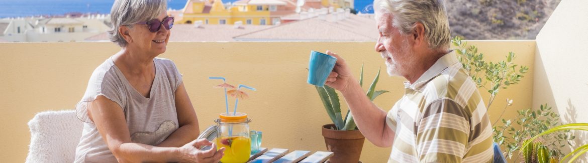 Elderly couple drink cocktail on rooftop
